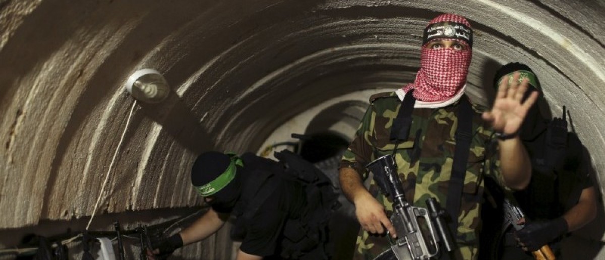 Izzのエルディーンアル・カッサム旅団からパレスチナの戦闘機、ハマス運動の武装翼、この2014年8月18日ファイルの写真でガザの地下トンネル内のジェスチャー。 REUTERS /モハメド・セーラム/ファイル