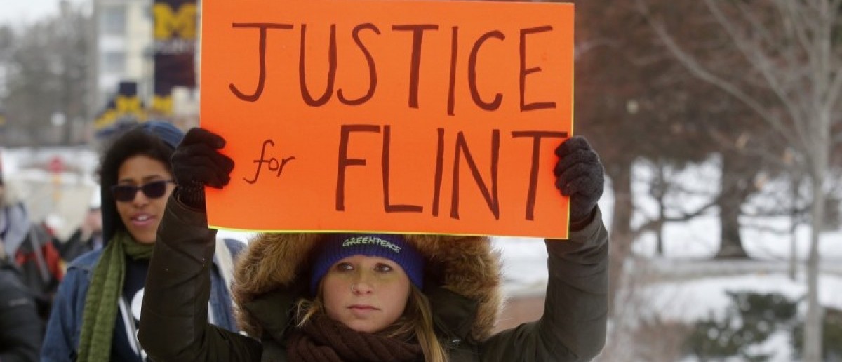 Demonstrators protest over the Flint, Michigan contaminated water crisis outside of the venue where the Democratic U.S. presidential candidates