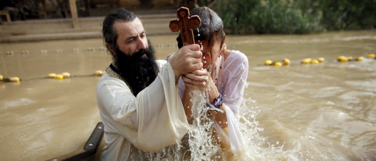 A Christian pilgrim is baptised as she takes part in a ceremony at the baptismal site known as Qasr el-Yahud on the banks of the Jordan River, near the West Bank city of Jericho January 18, 2016. Thousands of Orthodox Christians flocked to the Jordan River to celebrate the feast of the Epiphany at the traditional site where it is believed John the Baptist baptised Jesus. REUTERS/Nir Elias 
