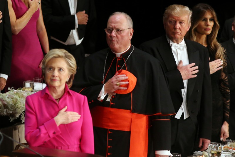 Donald Trump looks at Hillary Clinton during the national anthem as they attend the Alfred E. Smith Memorial Foundation dinner to benefit Catholic charities in New York. REUTERS/Carlos Barria