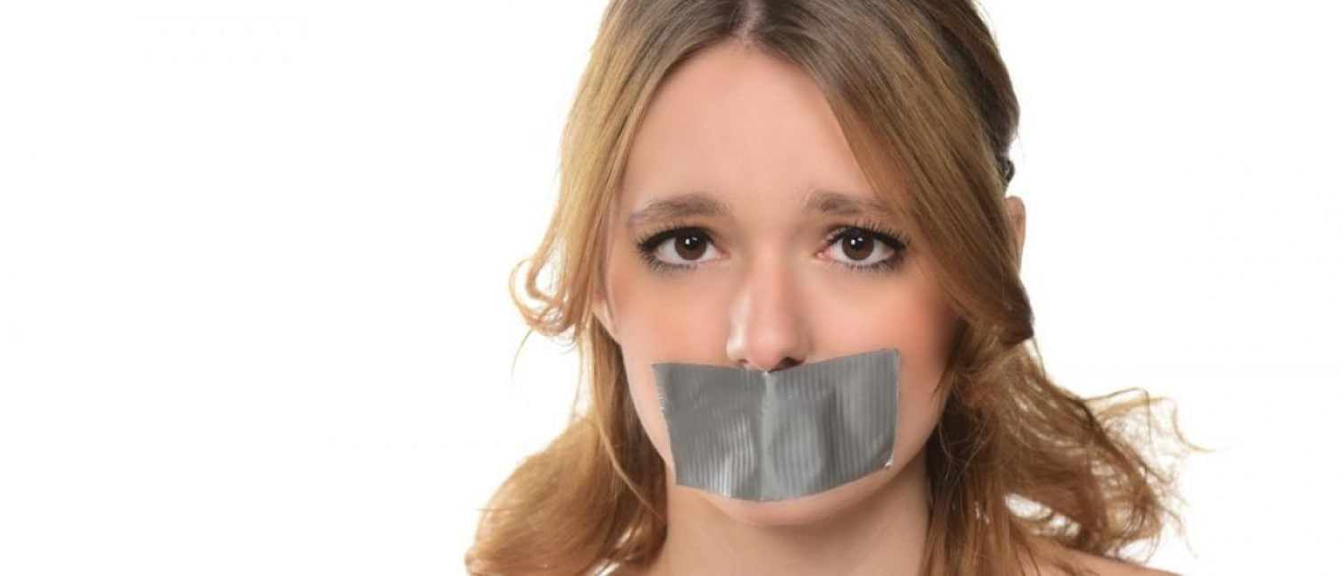 Young woman with tape over her mouth (Shutterstock/bobanphotomkd)