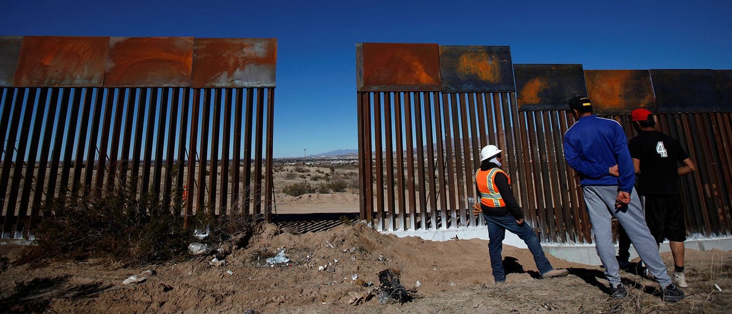 A worker chats with residents at a newly built section of the U.S.-Mexico border fence at Sunland Park, U.S. opposite the Mexican border city of Ciudad Juarez, Mexico January 26, 2017. (PHOTO: REUTERS/Jose Luis Gonzalez)