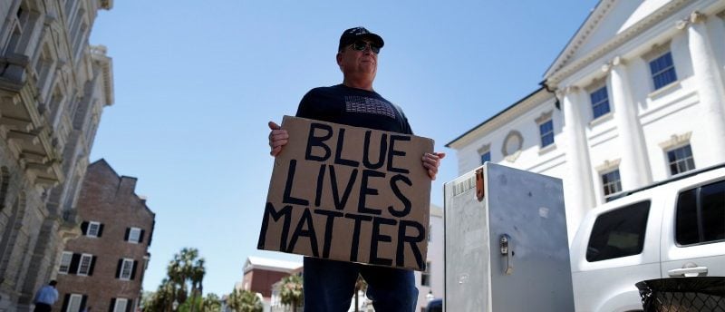 A lone Blue Lives Matter supporter holds a sign outside the Federal Courthouse before the Federal court hearing of former North Charleston police officer Michael Slager in Charleston, South Carolina May 2, 2017. REUTERS/Randall Hill
