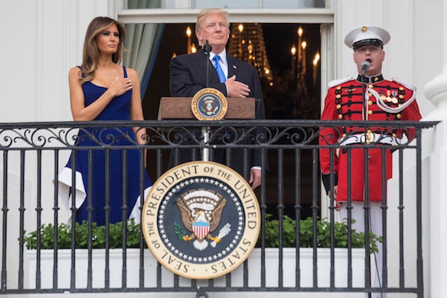 WASHINGTON, DC - JULY 4: U.S. President Donald Trump and first lady Melania Trump observe the playing of the national anthem from the Truman Balcony on July 4, 2017 in Washington, DC. The president was hosting a picnic for military families for the July 4 holiday. (Photo by Zach Gibson/Getty Images)