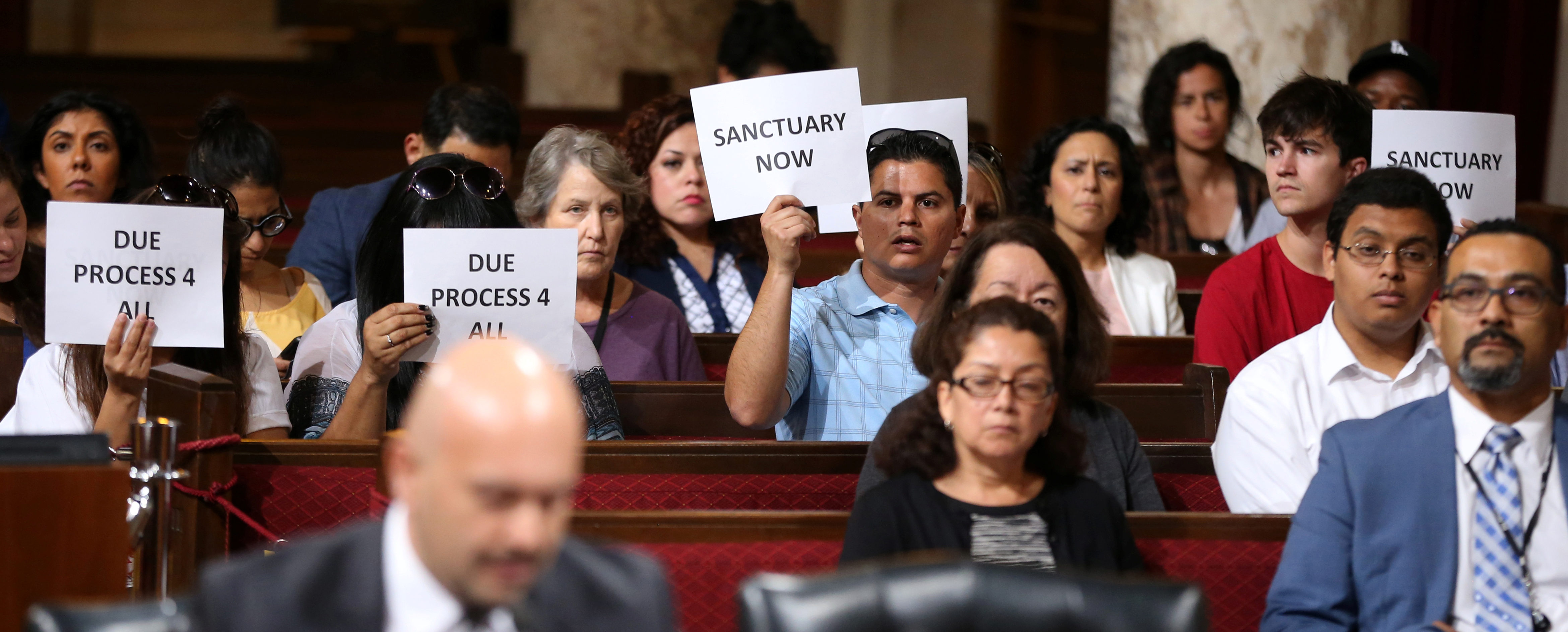 Immigrant supporters protest during the Los Angeles City Council ad hoc committee on immigration meeting to discuss the city's response to threats by the Trump administration to cut funding from Los Angeles and other jurisdictions which federal officials say are providing sanctuary to illegal immigrants arrested for crimes, in Los Angeles, California, U.S., March 30, 2017. REUTERS/Lucy Nicholson