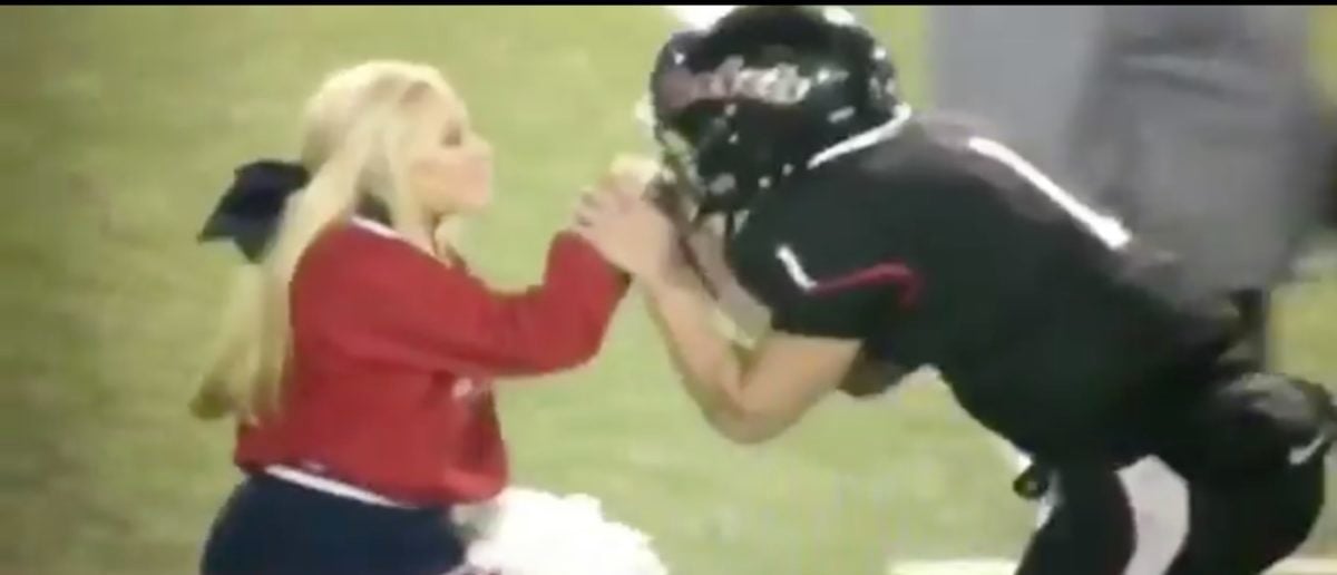 Cheerleader Grabs QB By His Facemask Drags Him Around In Hilarious Fashion