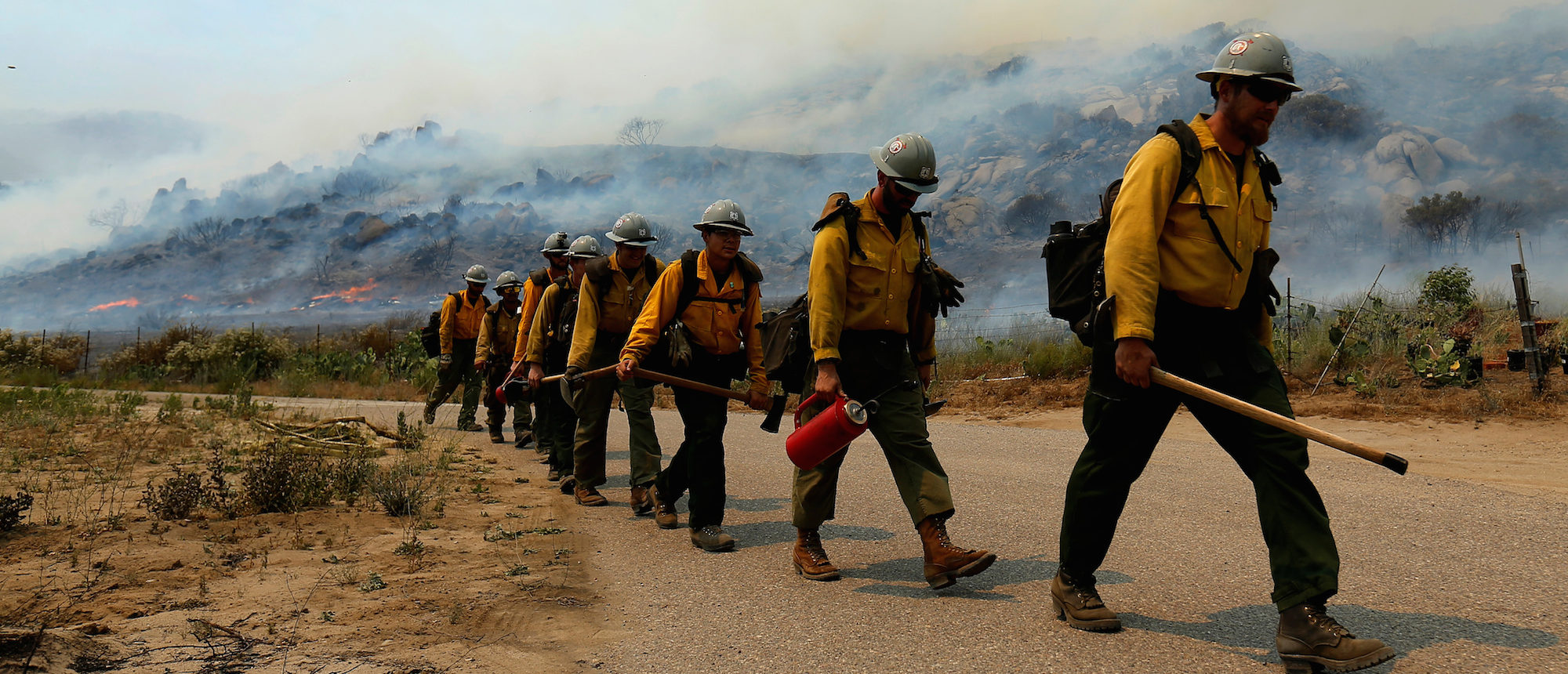 U.S. Forest Service firefighters walk to their truck after battling a wildfire near Potrero California, June 20, 2016. REUTERS/Mike Blake