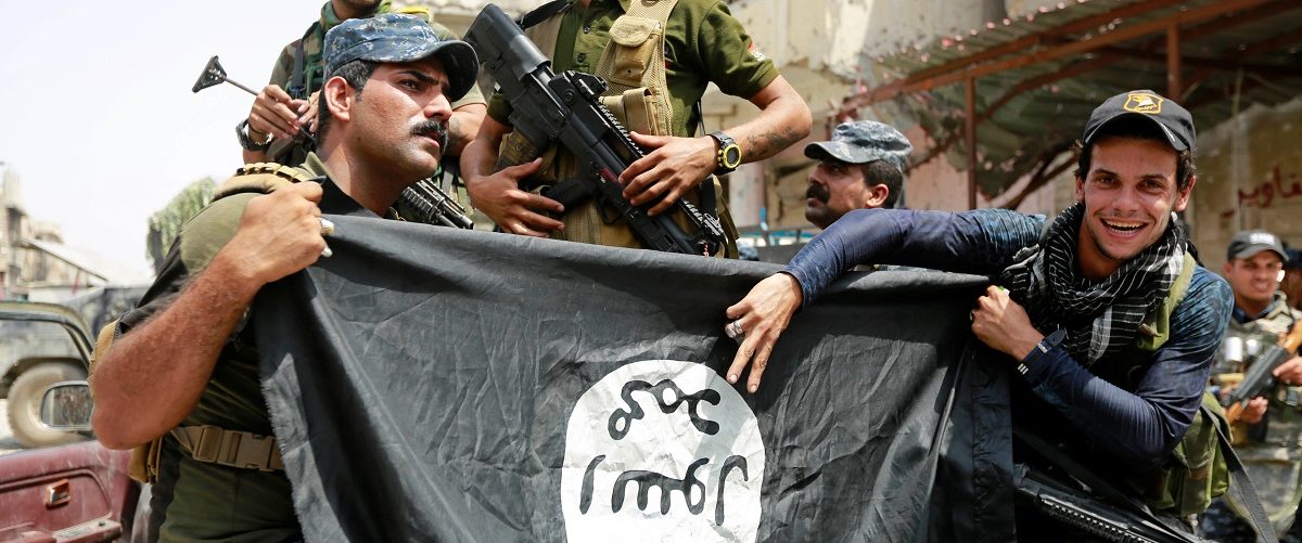 Iraqi Federal Police members hold an Islamic State flag, which they pulled down during fighting between Iraqi forces and Islamic State militants, in the Old City of Mosul, Iraq July 4, 2017. REUTERS/Ahmed Saad.