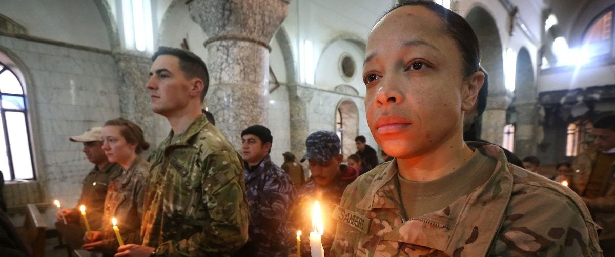 US Soldiers attend a Christmas Eve service for Iraqi Christians at the Saint John's church (Mar Yohanna church) in the town of Qaraqosh (also known as Hamdaniya), 30 kms east of Mosul, on December 25, 2016. Safin Hamed/AFP/Getty Images.