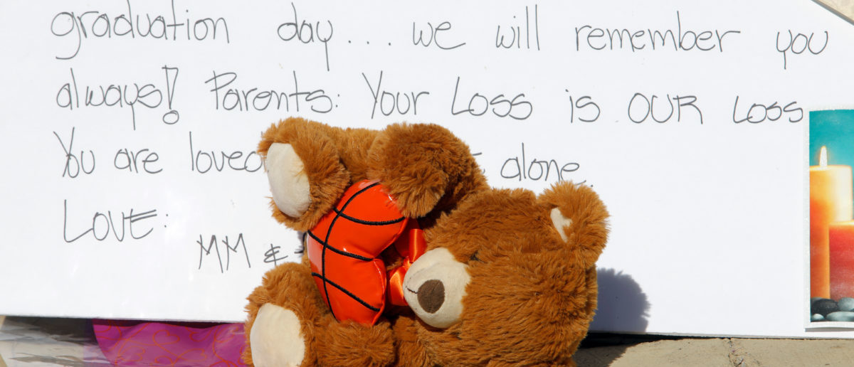 A stuffed toy slumps over in front of a sign at a makeshift memorial on a fence close to Marjory Stoneman Douglas High School three days after the school shooting in Parkland, Florida, U.S., February 17, 2018. REUTERS/Jonathan Drake 