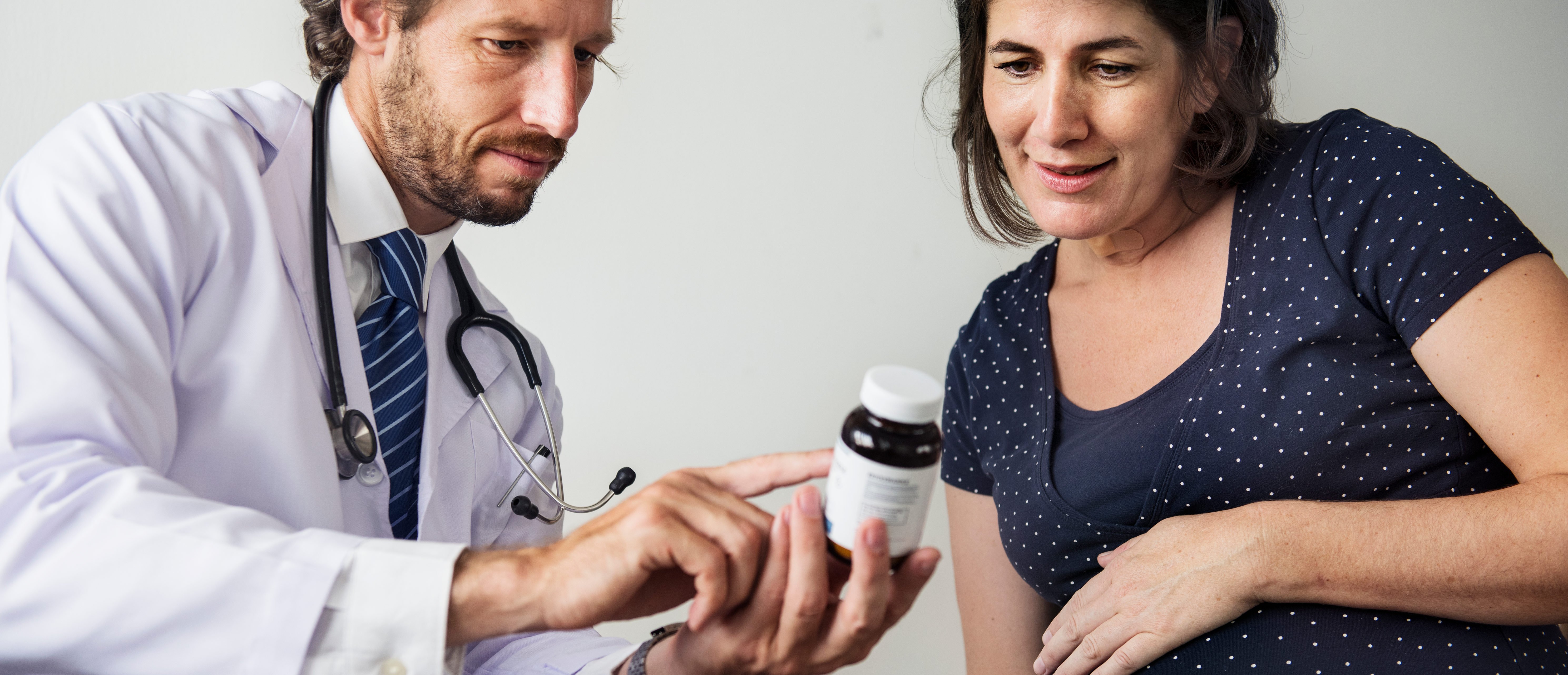 Doctor talking to woman about her baby (Shutterstock/RawPixel)