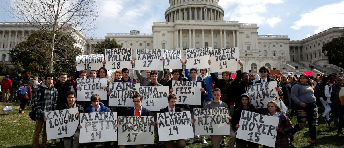 Students from Gonzaga College High School in Washington, DC, hold up signs with the names of those killed in the Parkland, Florida, school shooting during a protest for stricter gun control during a walkout by students at the U.S. Capitol in Washington, U.S., March 14, 2018.     REUTERS/Joshua Roberts | Students Criticize Media 