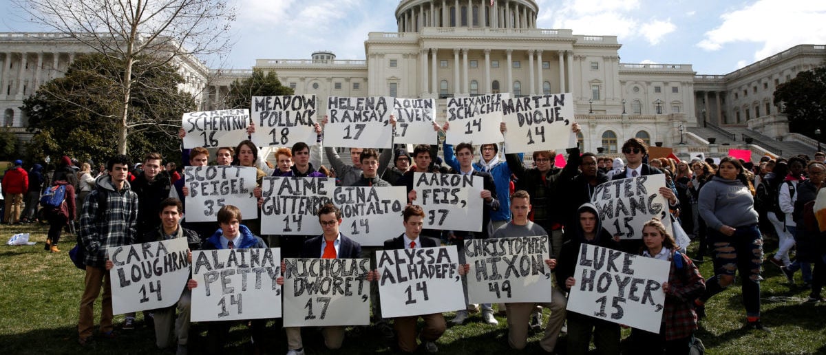 Students from Gonzaga College High School in Washington, DC, hold up signs with the names of those killed in the Parkland, Florida, school shooting during a protest for stricter gun control during a walkout by students at the U.S. Capitol in Washington, U.S., March 14, 2018.     REUTERS/Joshua Roberts   