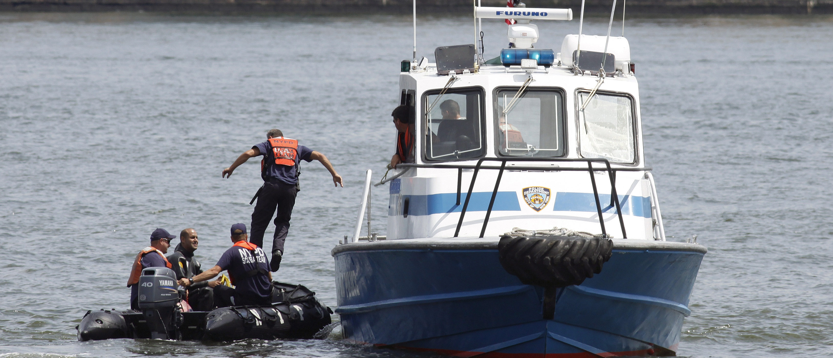A NYPD scuba team is on site of a crash between a helicopter and an aircraft over the Hudson River, between New York and Hoboken, New Jersey, August 8, 2009. The tour helicopter collided with the small plane in midair and both crashed into the Hudson River near lower Manhattan, police reported on Saturday.     REUTERS/Gary Hershorn   