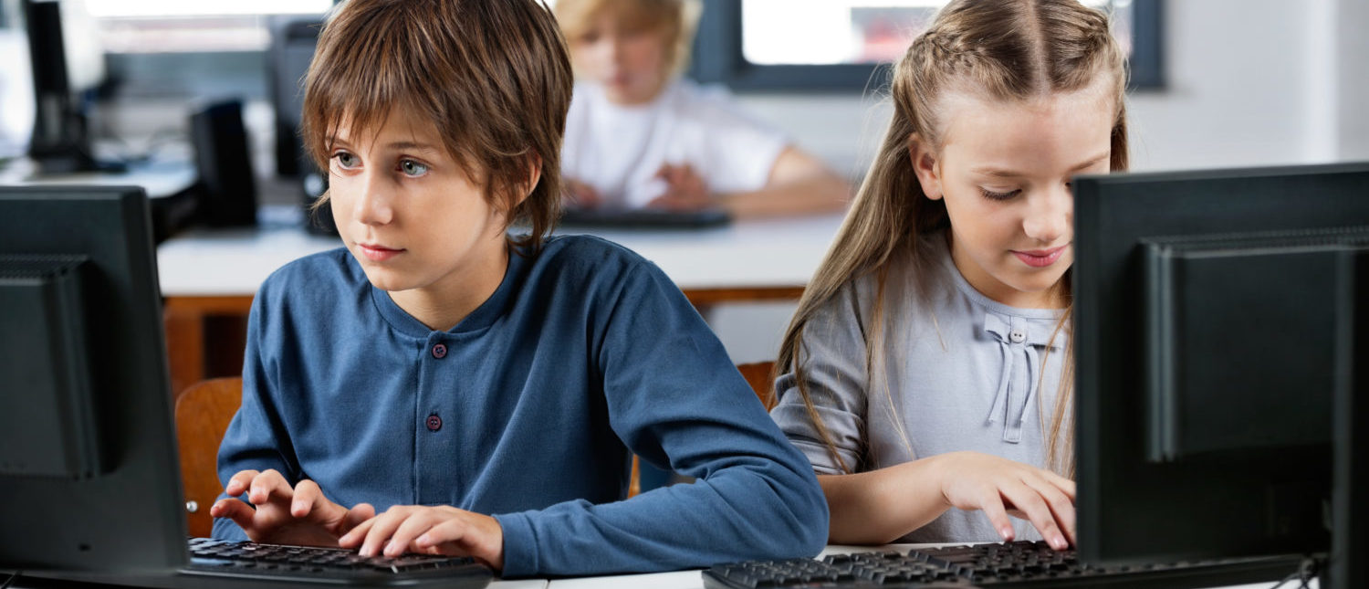 Children at school using computers for educational purposes. [Shutterstock - Tyler Olson]