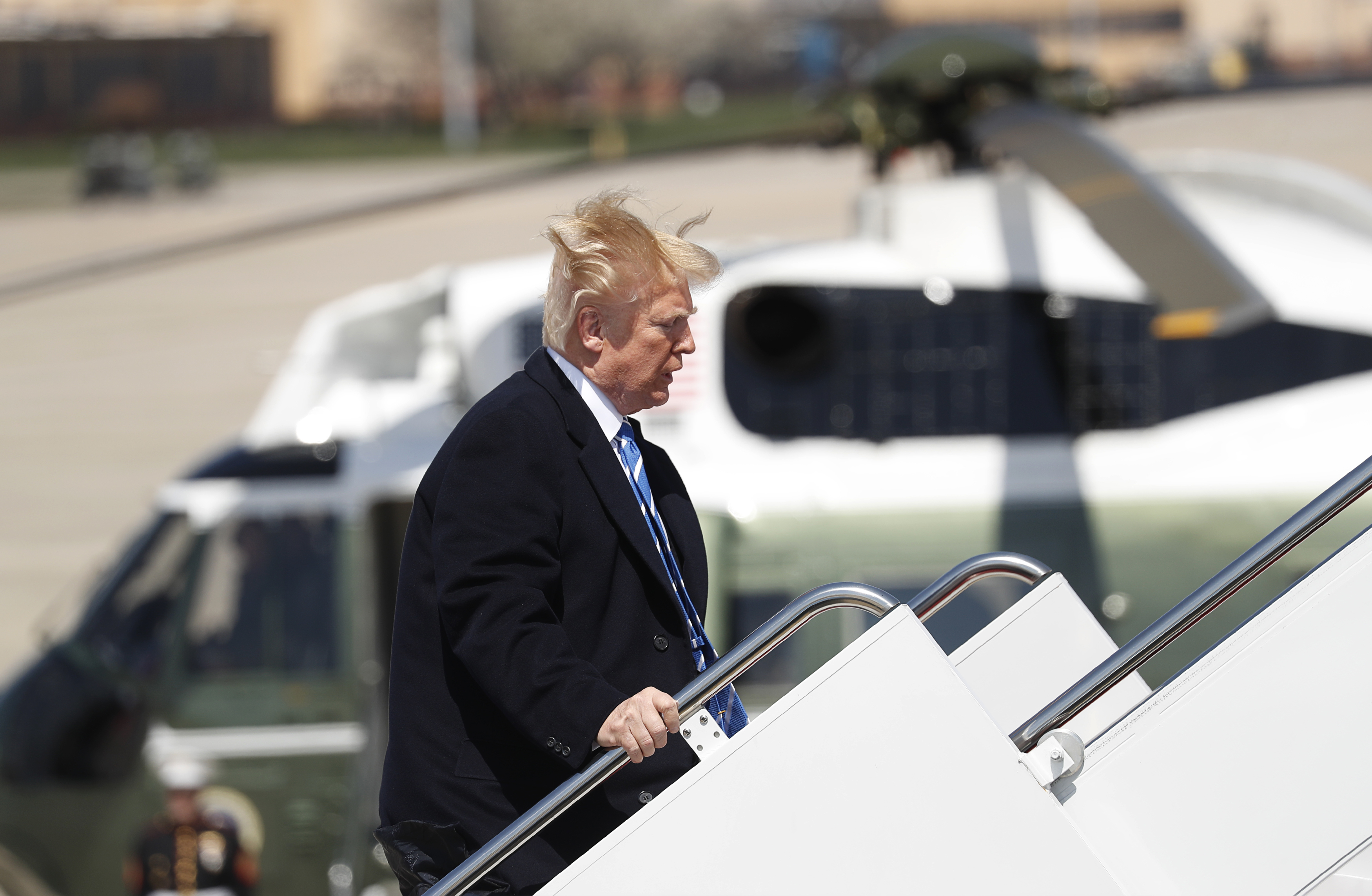 U.S. President Donald Trump yells over to members of the news media as he boards Air Force One on a windy day at Joint Base Andrews, Maryland before departing en route to an event in West Virginia, U.S., April 5, 2018. (REUTERS/Kevin Lamarque)