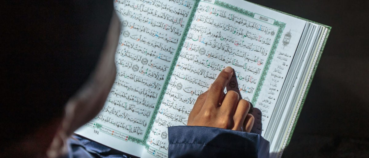 Kid Reading the Quran (shutterstock/ Yusnizam Yusof) | School Asks Kids To Write Shahada