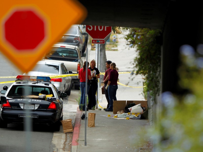 Police investigate the scene under a highway overpass where another apparent attack by a serial killer targeting homeless men took place overnight in San Diego, California