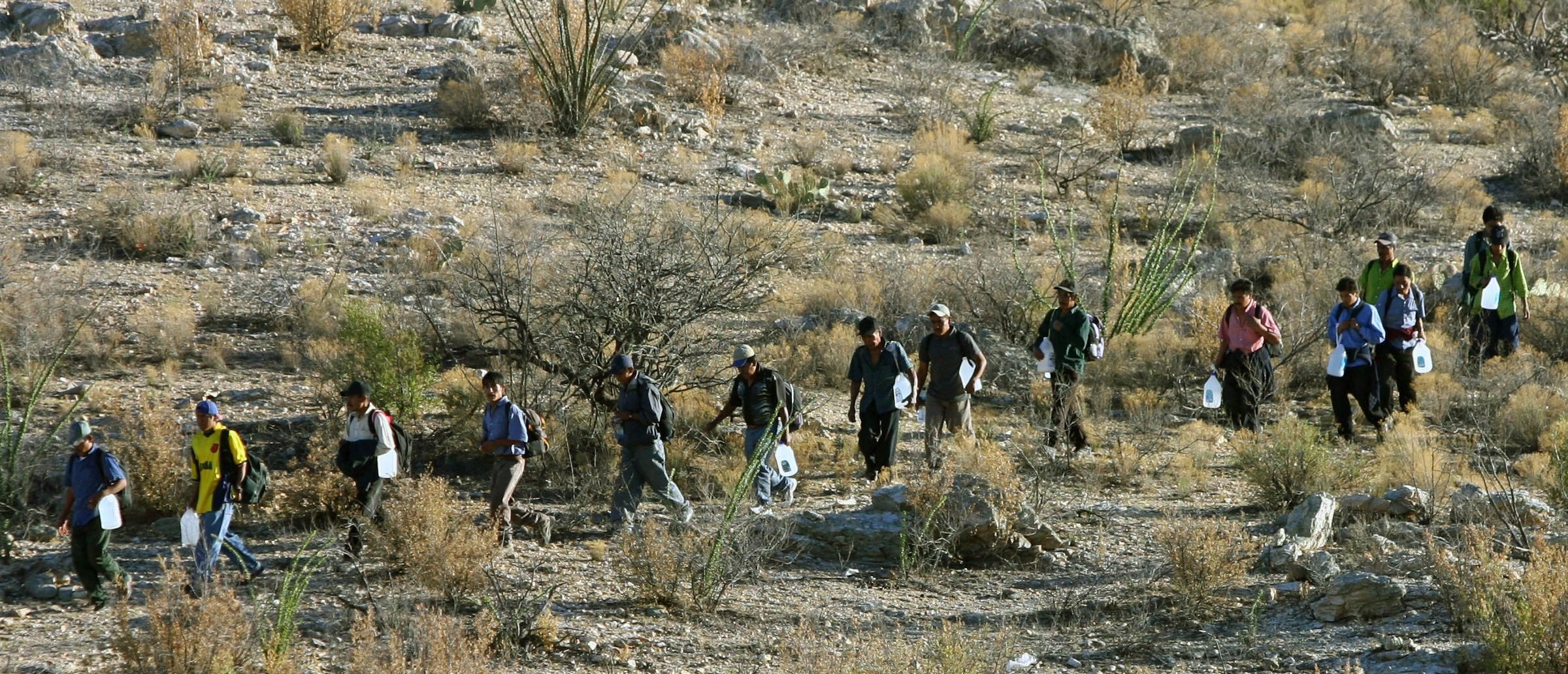 Mexican immigrants walk in line through the Arizona desert near Sasabe, Sonora state, in an attempt to illegally cross the Mexican-US border, 06 April 2006. While thousands of mexicans try to cross the border daily from Sasabe city, the US Senate reached a breakthrough agreement on a legislation that would grant legal residency status to millions of undocumented workers in the United States. AFP PHOTO/ Omar TORRES