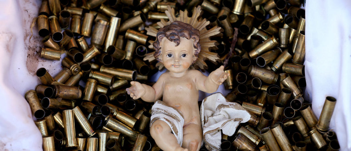 A statue of the baby Jesus on a bed of bullet shells is seen in a Nativity scene outside the Basilica of St Francis in Assisi, Italy, December 21, 2017. The 445 shells represent the number of priests, nuns, monks and religious teachers killed for their faith since 2000. Picture taken December 21, 2017. REUTERS/Alessandro Bianchi TPX IMAGES OF THE DAY