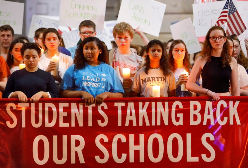High school students observe a moment of silence in memory of the victims of the shooting at Marjory Stoneman Douglas High School, during a demonstration calling for safer gun laws outside the North Carolina State Capitol building in Raleigh, North Carolina, U.S., February 20, 2018. REUTERS/Jonathan Drake