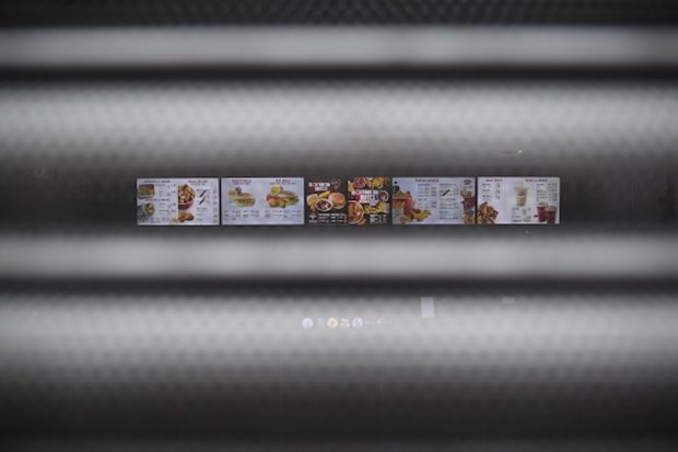 A sign seen through the shutters on a closed KFC fast food store in south London is closed on February 19, 2018 shows the menu. US fast food chain KFC said on February 19 it had been forced to close many restaurants in Britain because of a new supplier failing to deliver chicken in time, generating some tongue-in-cheek outrage on Twitter. / AFP PHOTO / BEN STANSALL (Photo credit should read BEN STANSALL/AFP/Getty Images)