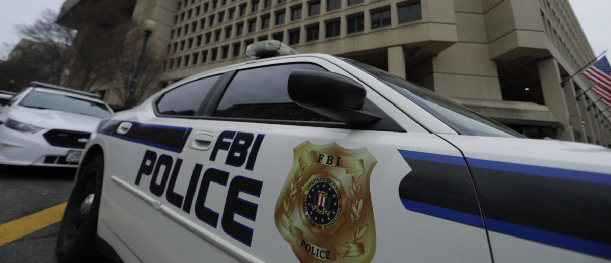 FBI Police vehicles sit parked outside of the J. Edgar Hoover Federal Bureau of Investigation Building in Washington, U.S., February 1, 2018. U.S. President Donald Trump is expected to announce soon that he will release a controversial memo that purports to show bias against him at the FBI and Justice Department as they investigated contacts between Trump's presidential campaign and Russia. REUTERS/Jim Bourg 