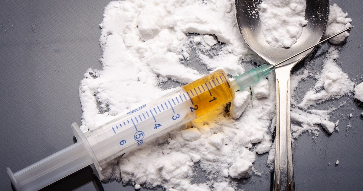 Drug syringe and cooked heroin on spoon. Evdokimov Maxim/Shutterstock