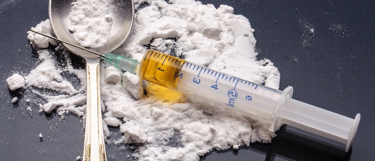 Drug syringe and cooked heroin on spoon. (Evdokimov Maxim/Shutterstock)