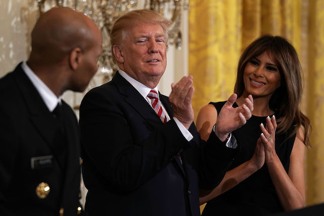 WASHINGTON, DC - FEBRUARY 13: U.S. President Donald Trump (2nd L) and first lady Melania Trump (R) applaud as Surgeon General Jerome Adams (L) looks on during a reception in the East Room of the White House February 13, 2018 in Washington, DC. President Trump and the first lady hosted a reception to celebrate the National African American History Month with leaders and representatives from the African American community. (Photo by Alex Wong/Getty Images)