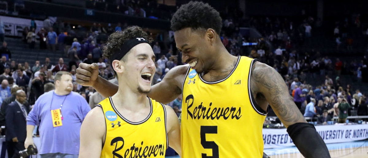 CHARLOTTE, NC - MARCH 16:  K.J. Maura #11 and teammate Jourdan Grant #5 of the UMBC Retrievers celebrate their 74-54 victory over the Virginia Cavaliers during the first round of the 2018 NCAA Men's Basketball Tournament at Spectrum Center on March 16, 2018 in Charlotte, North Carolina.  (Photo by Streeter Lecka/Getty Images)