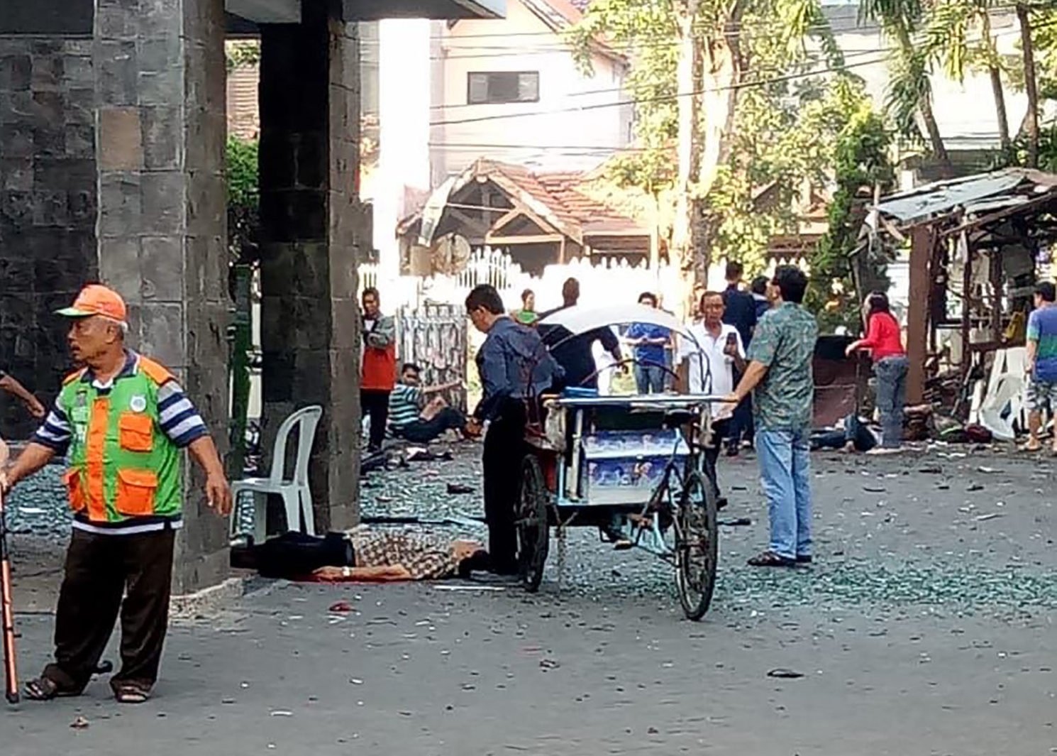 Bystanders observe the aftermath of a suicide bombing at a church in Surabaya, Indonesia on May 13, 2018. PHOTO: TheDCNF