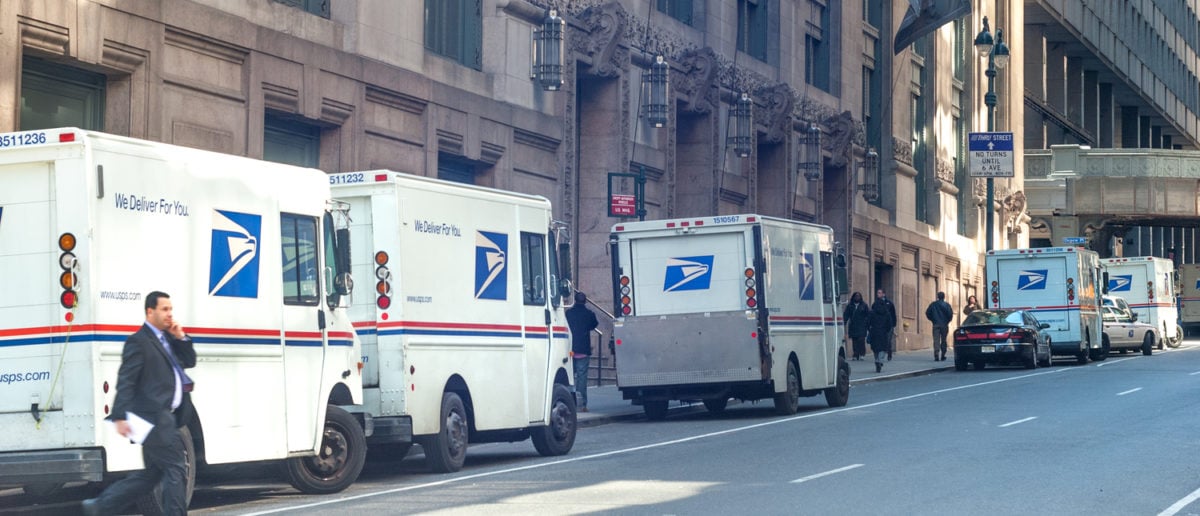USPS delivery trucks lined up by James A. Farley Post Office landmark building on March 25, 2008 in Midtown Manhattan, New York City, USA (Shutterstock/Natalia Bratslavsky)