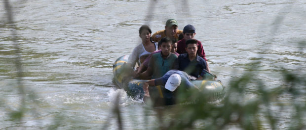 A suspected smuggler uses his arms to paddle a raft of immigrants across the Rio Grande in an illegal crossing of the Mexico-U.S. border near McAllen, Texas, U.S., May 9, 2018. REUTERS/Loren Elliott
