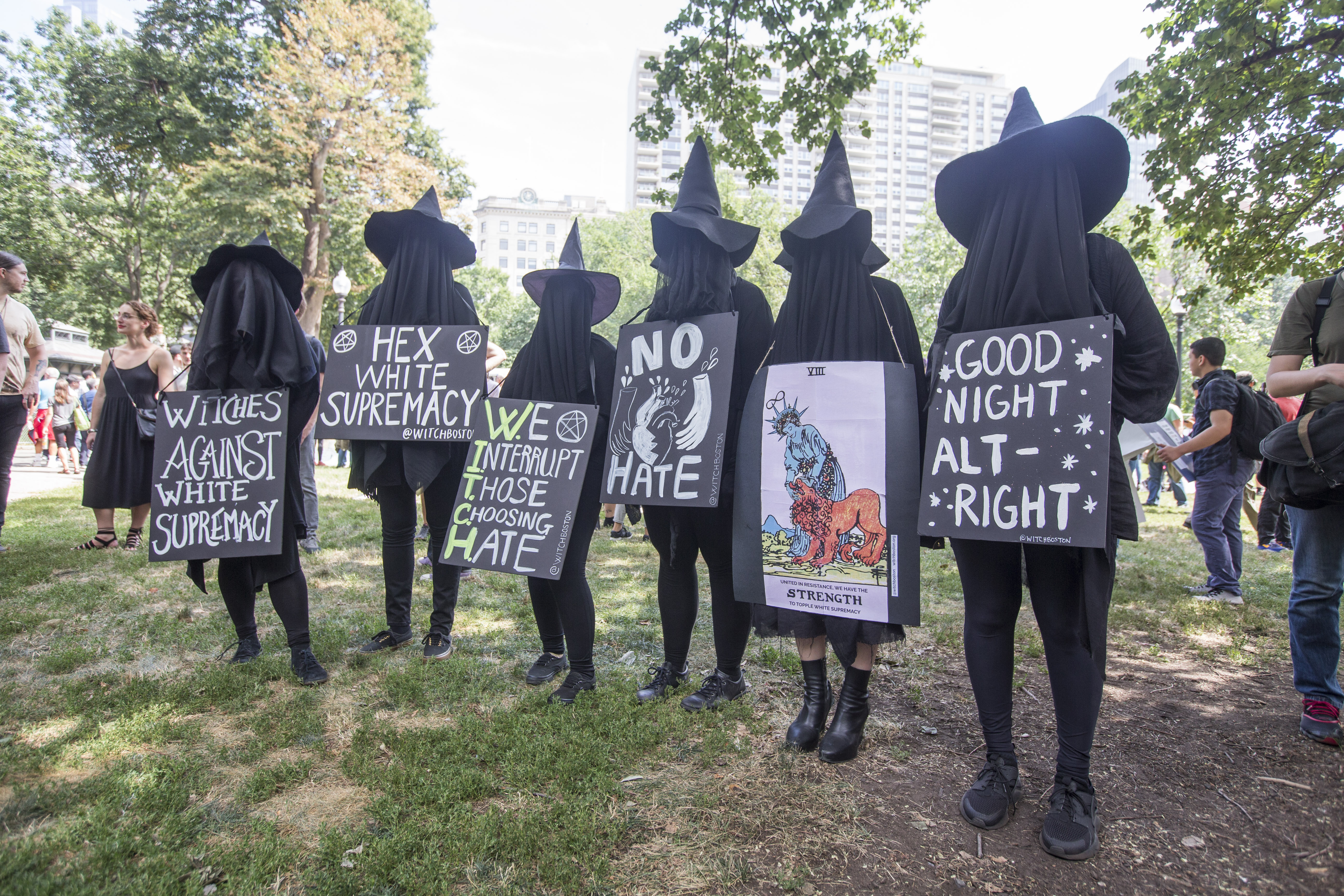 Counter protesters in witch costumes hold up signs after a march to the 'Free Speech Rally' on Boston Common on August 19, 2017 in Boston, Massachusetts. Thousands of demonstrators and counter-protestors are expected at Boston Common where the Boston Free Speech Rally is being held. (Photo by Scott Eisen/Getty Images)