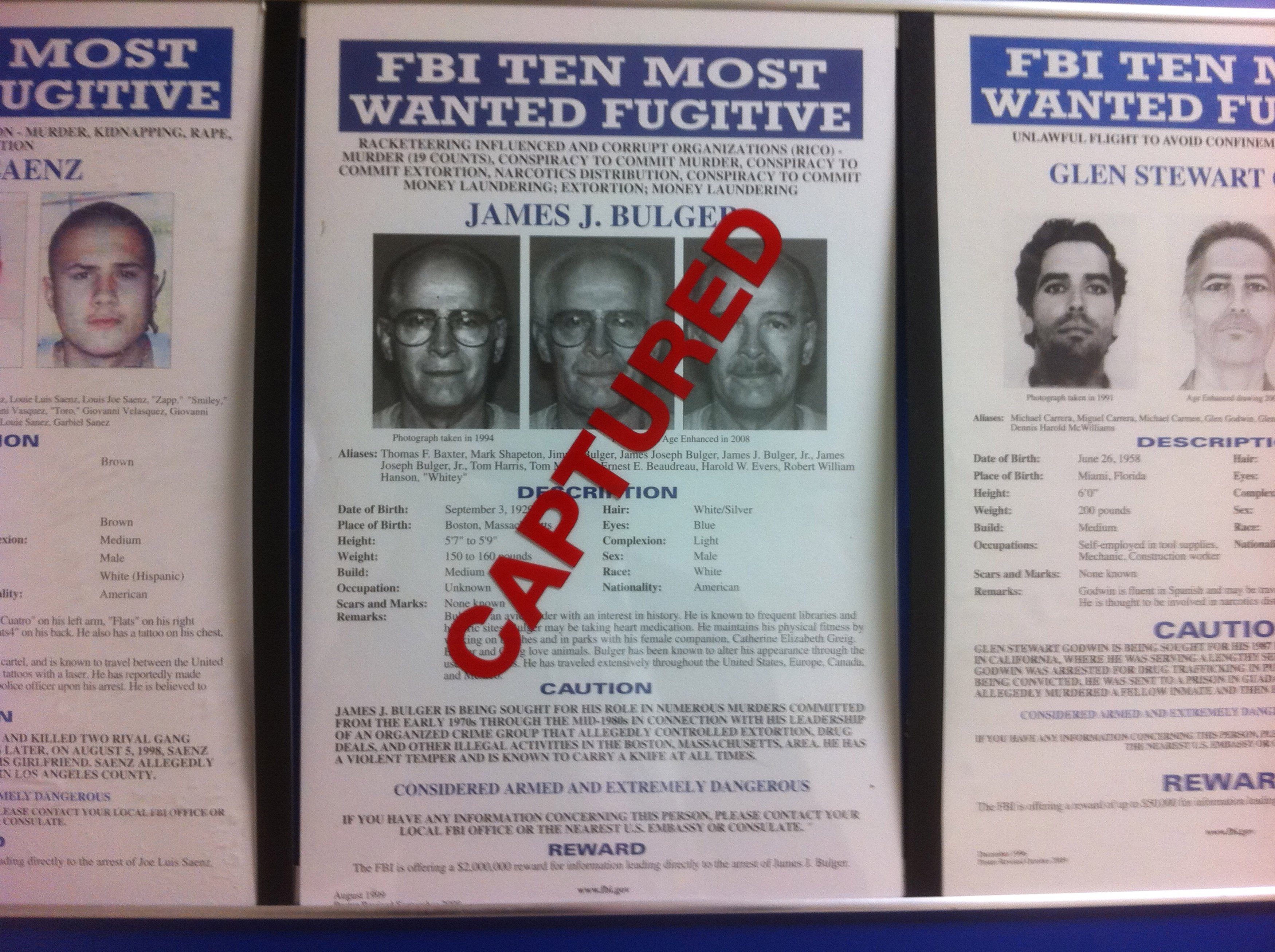 A most wanted poster for FBI Most Wanted fugitive and accused Boston crime boss James "Whitey" Bulger, is seen marked "CAPTURED" on a wall with other fugitive wanted posters at FBI headquarters in Washington, June 23, 2011. On the run for 17 years, Bulger and his longtime girlfriend were finally caught in California by the Federal Bureau of Investigation on Wednesday. REUTERS/FBI/Handout