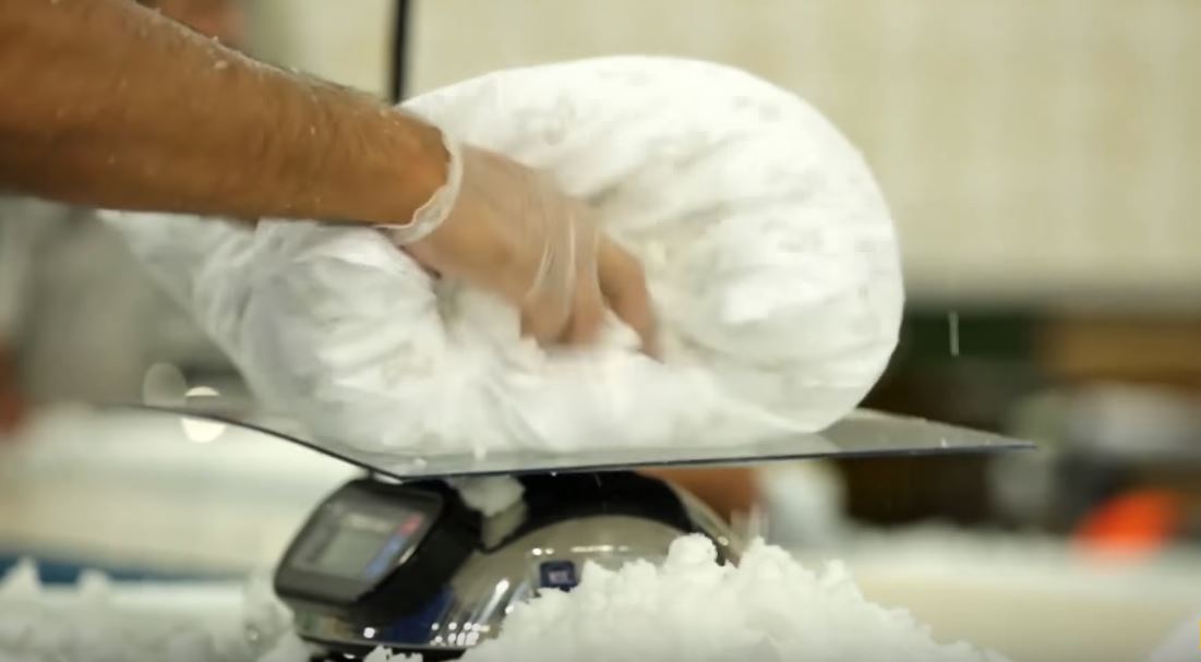 An employee stuffs a pillow at a MyPillow factory. YouTube screenshot/CNBC
