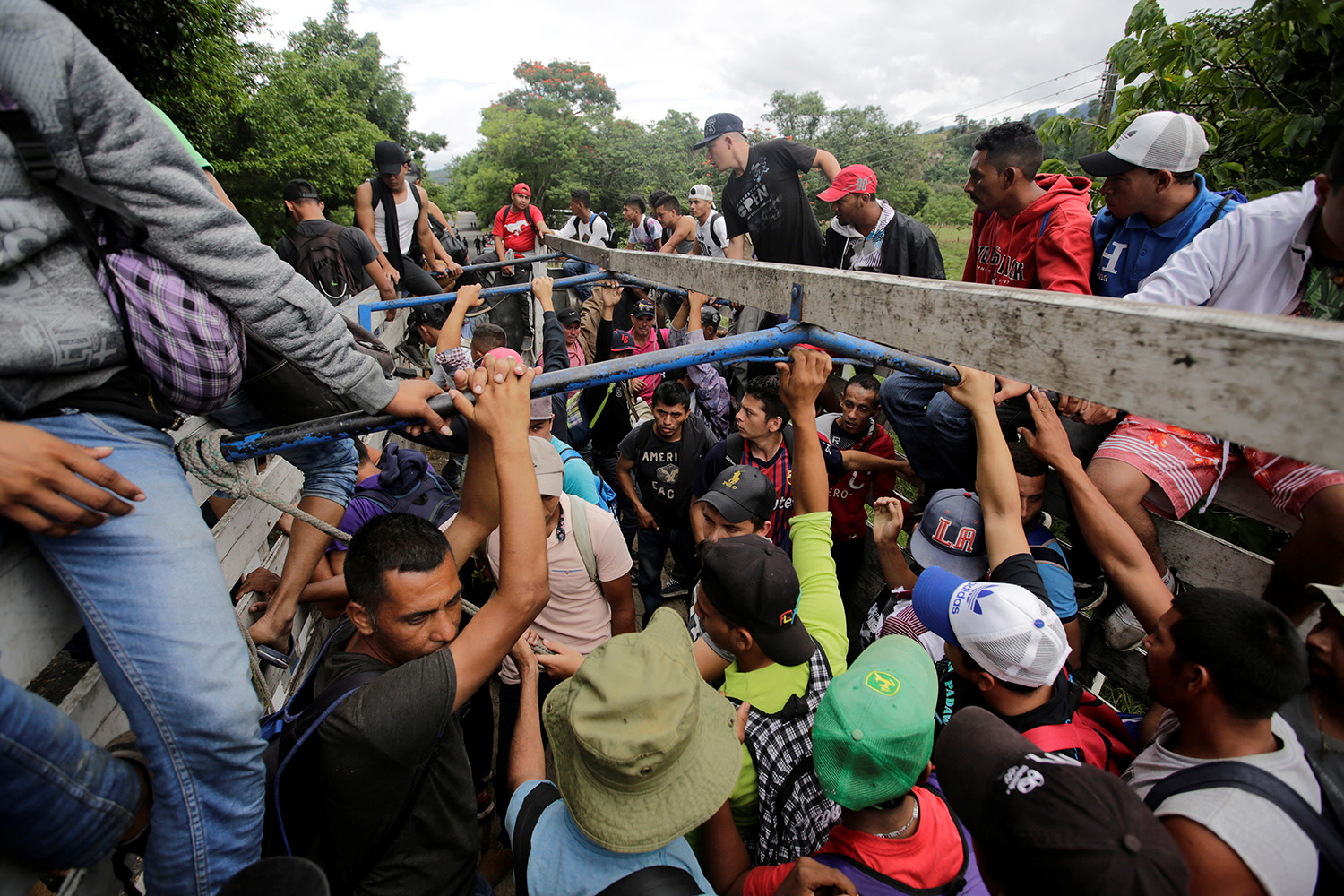 Honduran migrants board trucks sending them back to Honduras, after they crossed the border into Guatemala illegally in their bid to reach the U.S., in Agua Caliente, Guatemala October 17, 2018. REUTERS/Jorge Cabrera