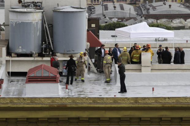 Authorities stand on the rooftop of the Cecil Hotel after a body was found in a water tank in Los Angeles, California, February 19, 2013. Police were trying to determine on Tuesday if a body found in a water tank on top of Cecil Hotel is that of a 21-year-old Canadian woman who went missing while staying there more than two weeks ago. Elisa Lam, a student from Vancouver, British Columbia who was visiting Southern California on her own, was last seen at the Cecil Hotel in downtown Los Angeles on January 31 and authorities had characterized her disappearance as suspicious. REUTERS/Jonathan Alcorn