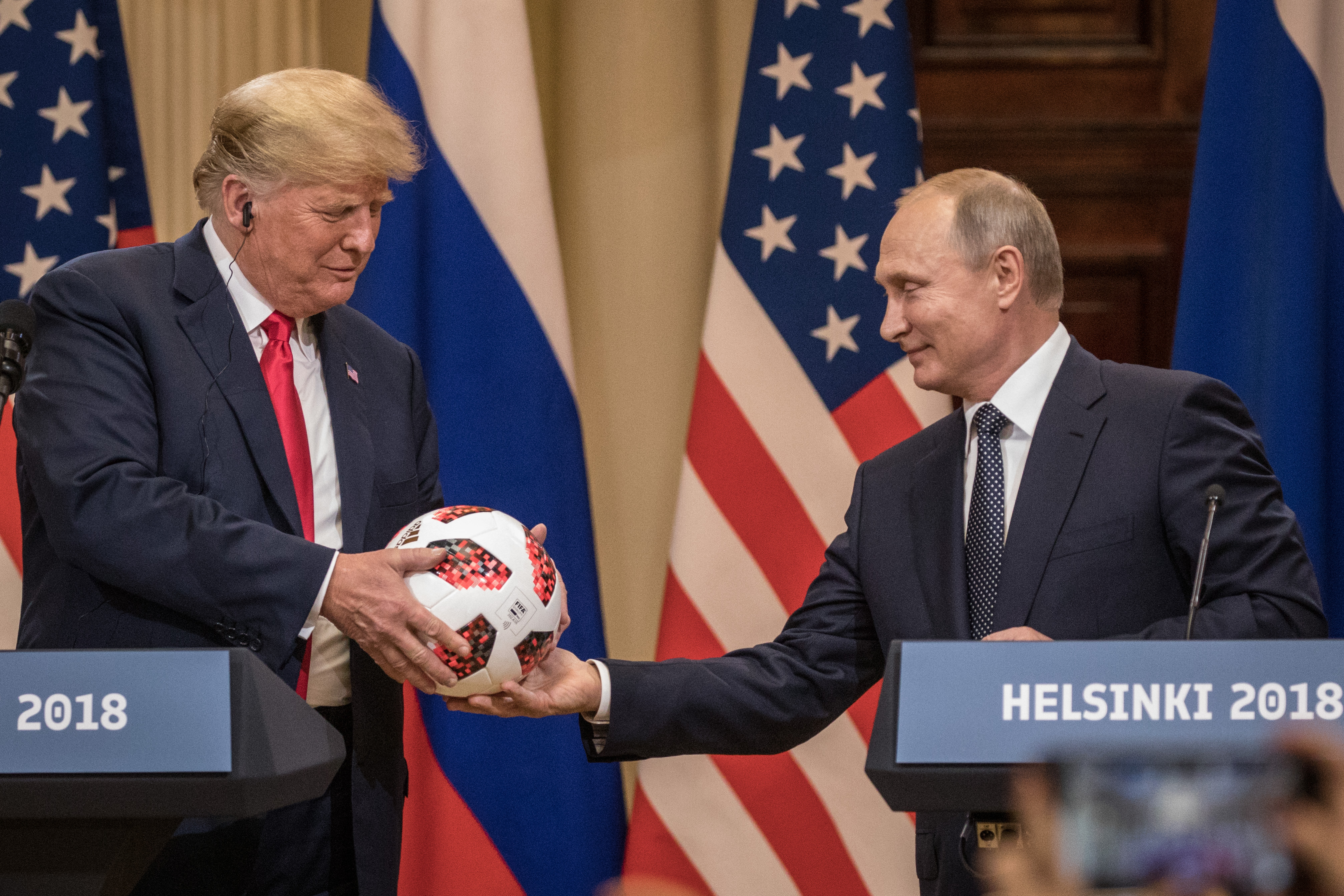 HELSINKI, FINLAND - JULY 16: Russian President Vladimir Putin hands U.S. President Donald Trump (L) a World Cup football during a joint press conference after their summit on July 16, 2018 in Helsinki, Finland. The two leaders met one-on-one and discussed a range of issues including the 2016 U.S Election collusion. (Photo by Chris McGrath/Getty Images)