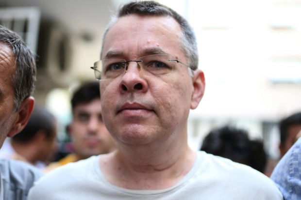 US pastor Andrew Craig Brunson escorted by Turkish plain clothes police officers arrives at his house on July 25, 2018 in Izmir. - Turkey on July 15, 2018 moved from jail to house arrest US pastor Andrew Brunson who has spent almost two years imprisoned on terror-related charges, in a controversial case that has ratcheted up tensions with the United States. Andrew Brunson, who ran a protestant church in the Aegean city of Izmir, was first detained in October 2016 and had remained in prison in Turkey ever since. (Photo by - / AFP) (Photo credit should read -/AFP/Getty Images)