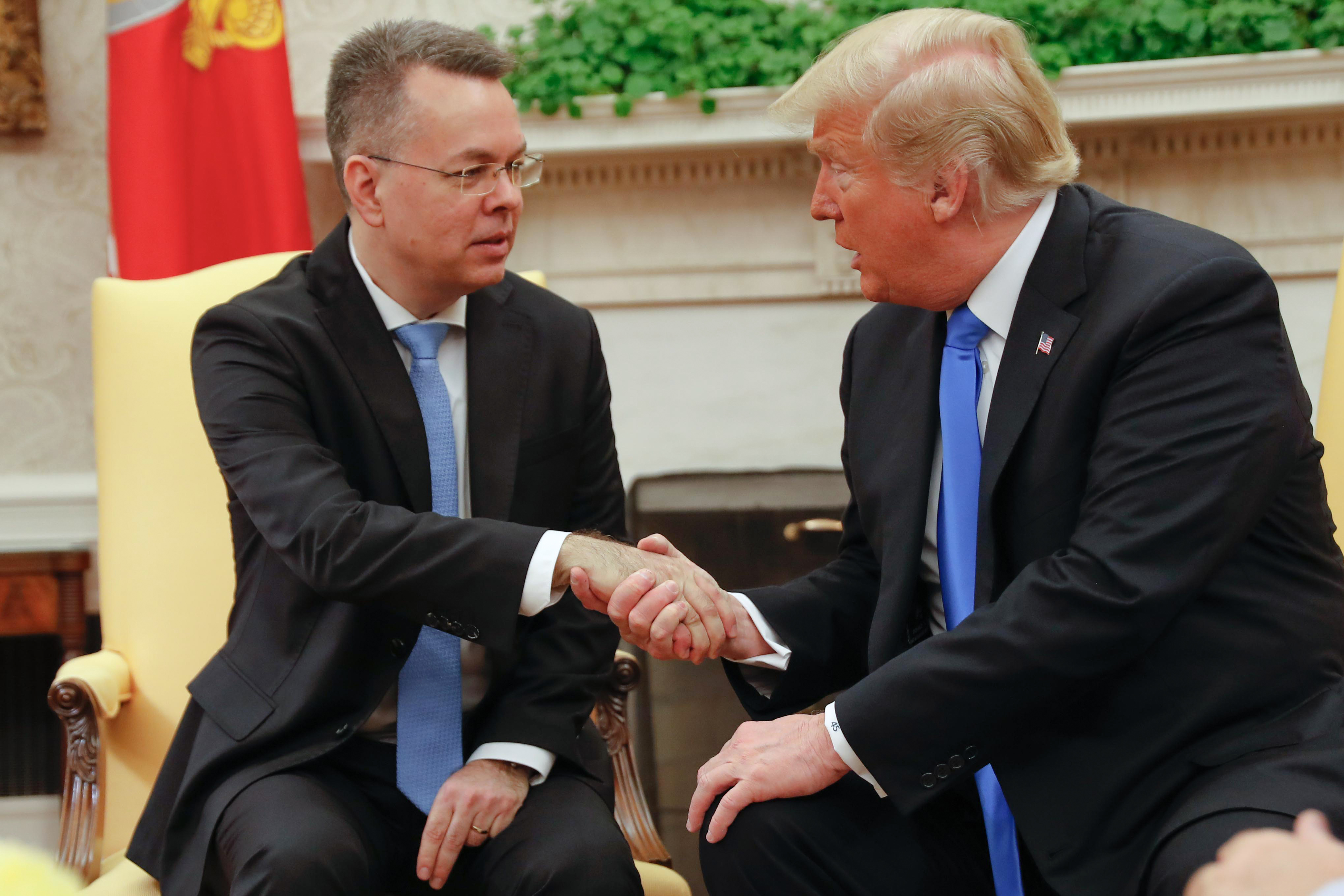 Freed American pastor Andrew Brunson (L) shakes hands with US President Donald Trump at the White House in Washington, DC, October 13, 2018. - Brunson, held for two years in Turkey, returned to the US earlier Saturday after a court freed him in a case that sparked a crisis in Ankara's ties with Washington and trouble for its economy. The court in the western town of Aliaga convicted Brunson on terror-related charges and sentenced him to three years, one month and 15 days in jail. (Photo by ROBERTO SCHMIDT / AFP) (Photo credit should read ROBERTO SCHMIDT/AFP/Getty Images)