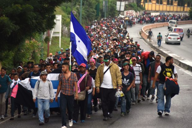 TOPSHOT - Honduran migrants take part in a caravan towards the United States in Chiquimula, Guatemala on October 17, 2018. - A migrant caravan set out on October 13 from the impoverished, violence-plagued country and was headed north on the long journey through Guatemala and Mexico to the US border. President Donald Trump warned Honduras he will cut millions of dollars in aid if the group of about 2,000 migrants is allowed to reach the United States. (Photo by ORLANDO ESTRADA / AFP) (Photo credit should read ORLANDO ESTRADA/AFP/Getty Images)