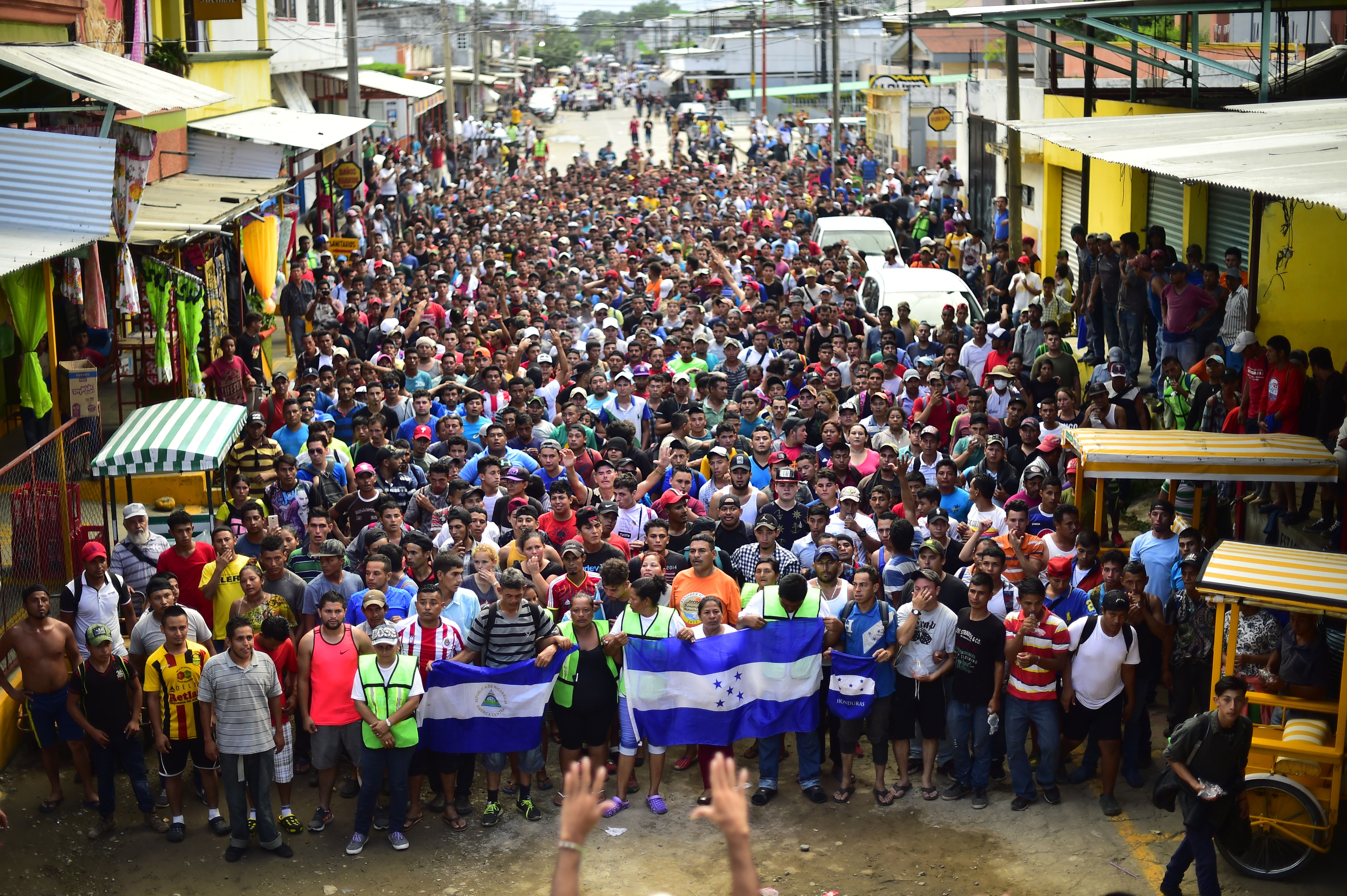 TOPSHOT - Honduran migrants heading in a caravan to the US, hold a demonstration demanding authorities to allow the rest of the group to cross, in Ciudad Hidalgo, Chiapas state, Mexico after crossing from Guatemala, on October 20, 2018. - Thousands of migrants who forced their way through Guatemala's northwestern border and flooded onto a bridge leading to Mexico, where riot police battled them back, on Saturday waited at the border in the hope of continuing their journey to the United States. (Photo by Pedro Pardo / AFP) 