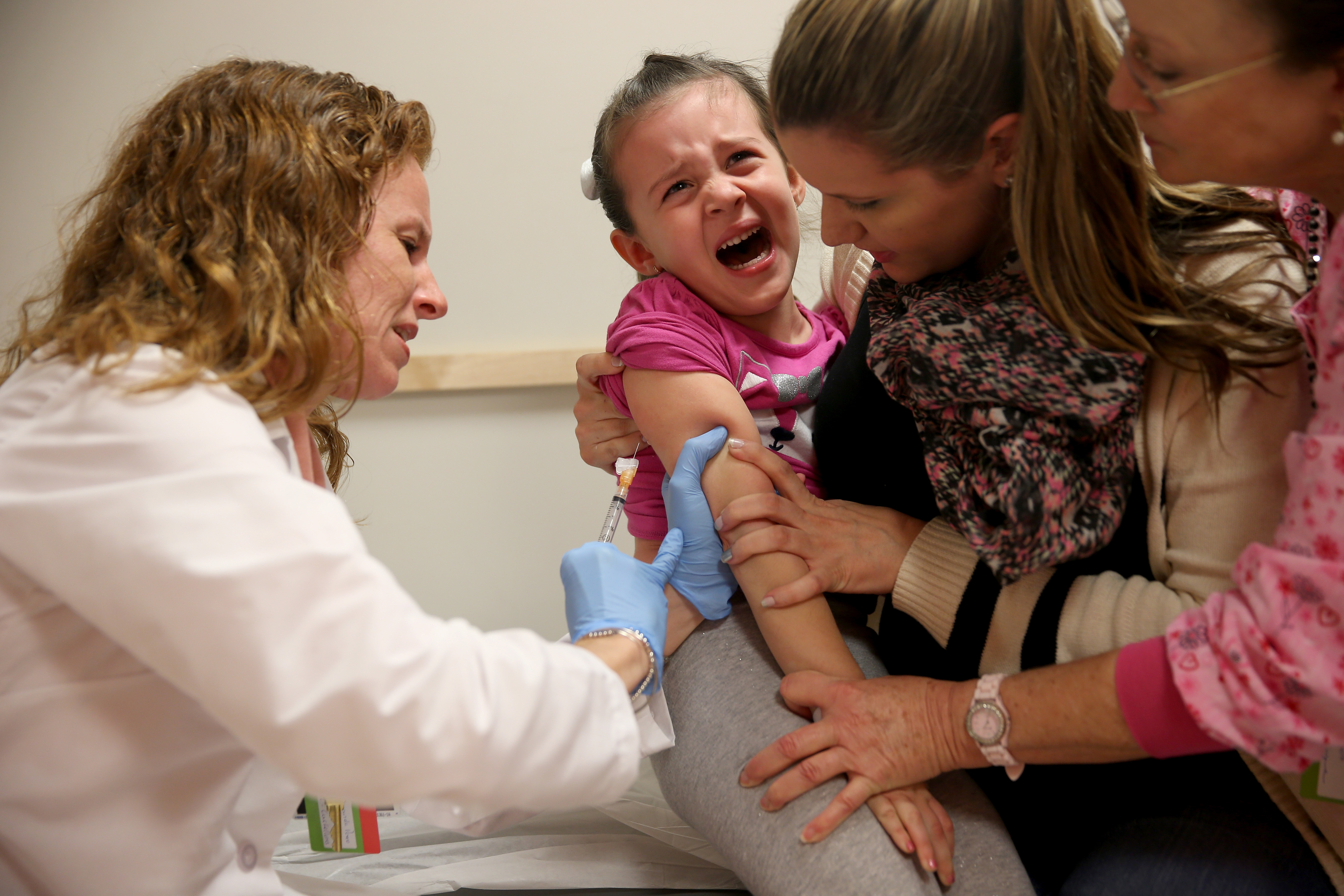 Miami Children's Hospital pediatrician Dr. Amanda Porro, M.D administers a measles vaccination to Sophie Barquin, 4, as her mother Gabrielle Barquin and Miami Children's Hospital. Photo by Joe Raedle/Getty Images