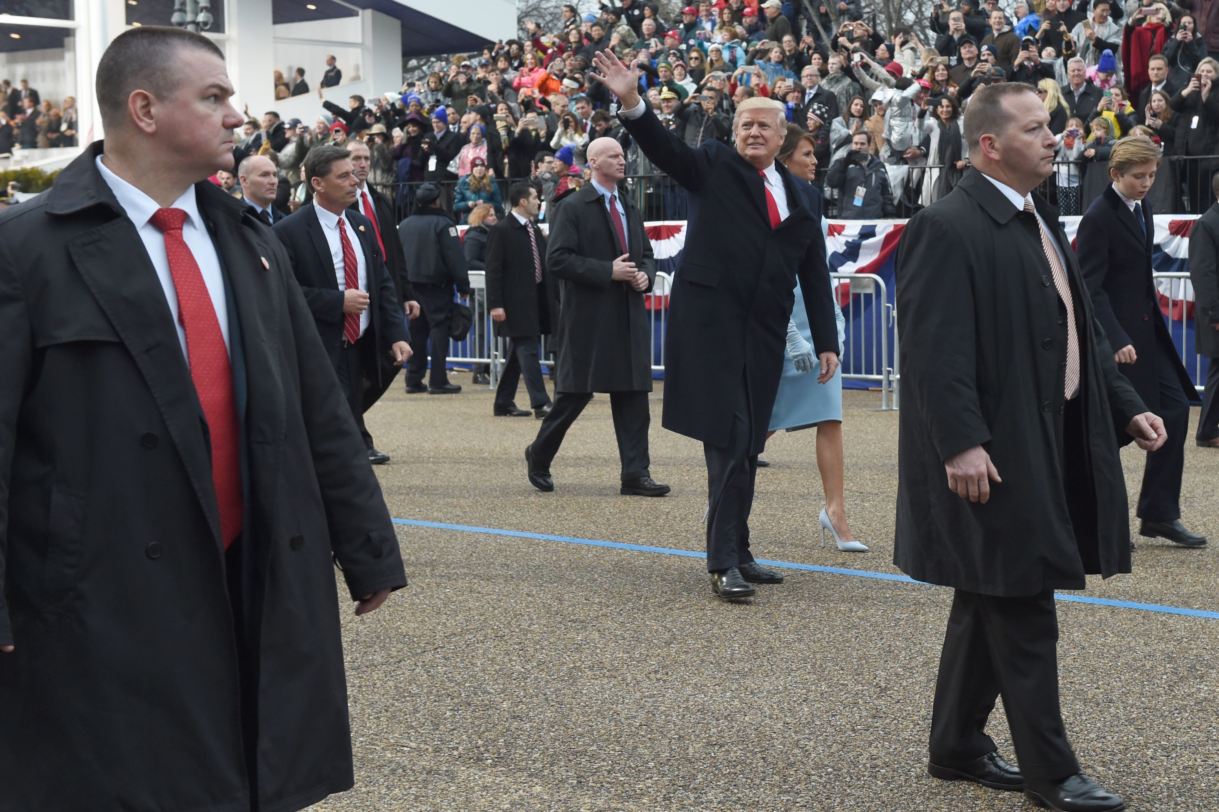 US President Donald Trump walks with his wife Melania surrounded by Secret Service officers outside the White House as the presidential inaugural parade winds through the nation's capital on January 20, 2017 in Washington, DC. TIMOTHY A. CLARY/AFP/Getty Images