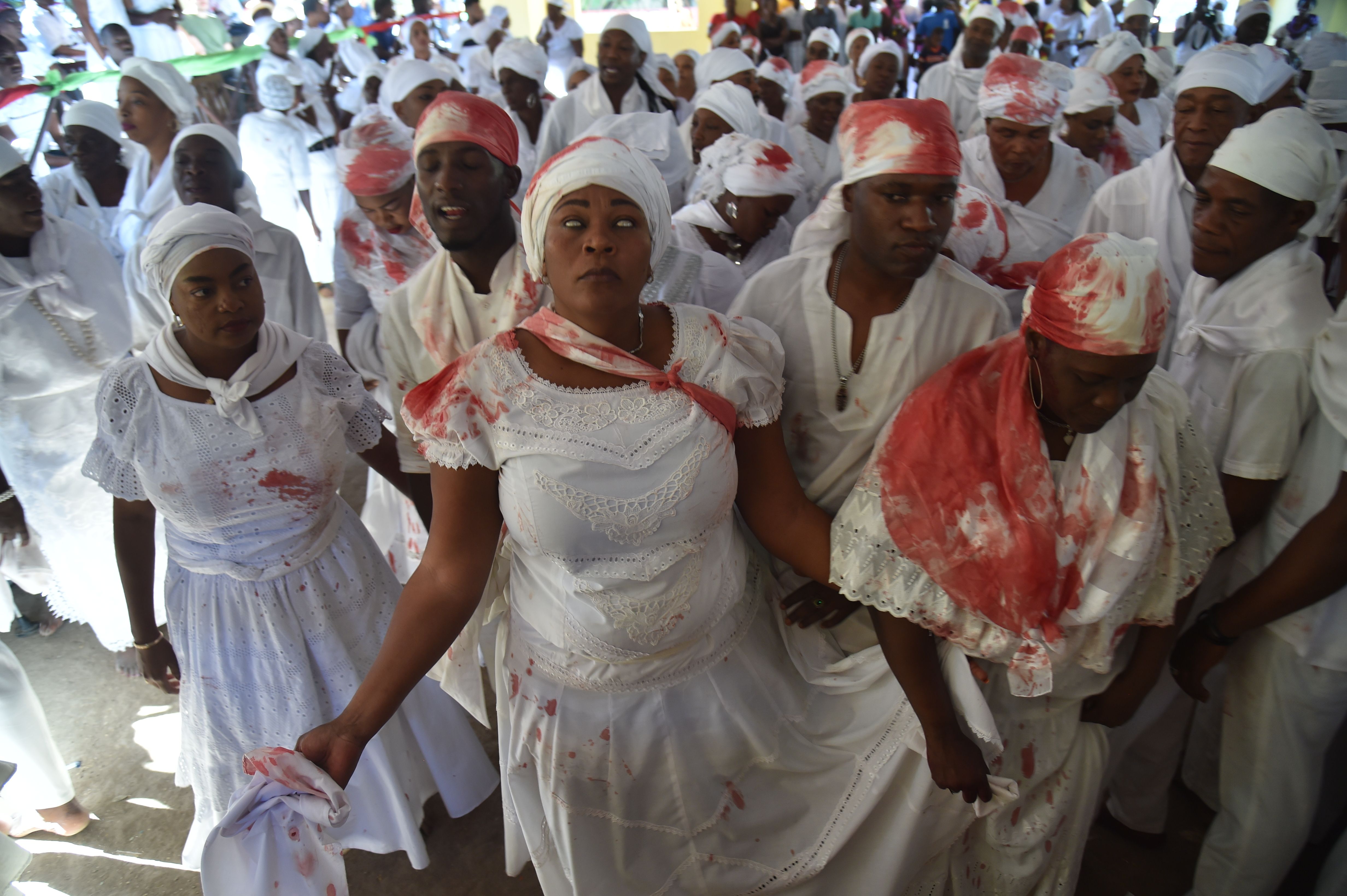 TOPSHOT - A Haitian voodoo follower wearing white clothes is seen in trance while participate in a voodoo ceremony in Souvenance, a suburb of Gonaives, 171km north of Port-au-Prince, on April 1, 2018. Haitian voodoo followers arrived in Souvenance to take part in the voodoo ceremonies held during Easter weekend. (HECTOR RETAMAL/AFP/Getty Images)