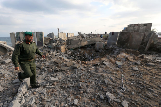 A member of Palestinian security forces loyal to Hamas inspects the scene of an Israeli air strike in the southern Gaza Strip October 17, 2018. REUTERS/Ibraheem Abu Mustafa