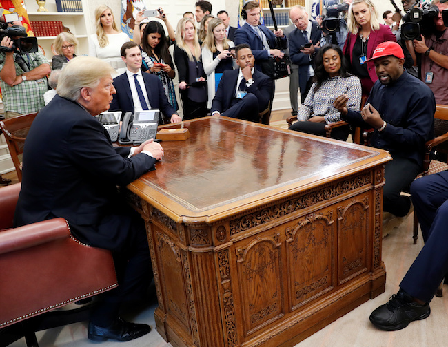 President Donald Trump listens to rapper Kanye West during a meeting in the Oval Office at the White House in Washington, October 11, 2018. REUTERS/Kevin Lamarque