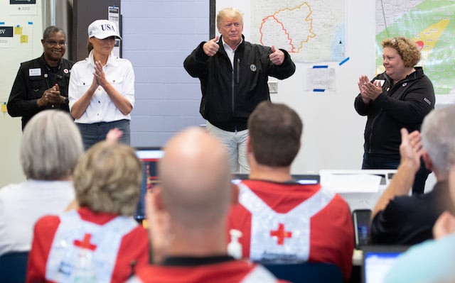 US President Donald Trump and First Lady Melania Trump meet with Red Cross workers in Macon, Georgia, October 15, 2018. - President Donald Trump toured areas of Florida devastated by Hurricane Michael last week, and met some of the thousands of people still struggling to survive without running water or electricity. Trump's tour took him past the base before he took off again in Air Force One for Georgia, which also suffered damage as the storm plowed across the southeast of the country.(Photo credit: SAUL LOEB/AFP/Getty Images)